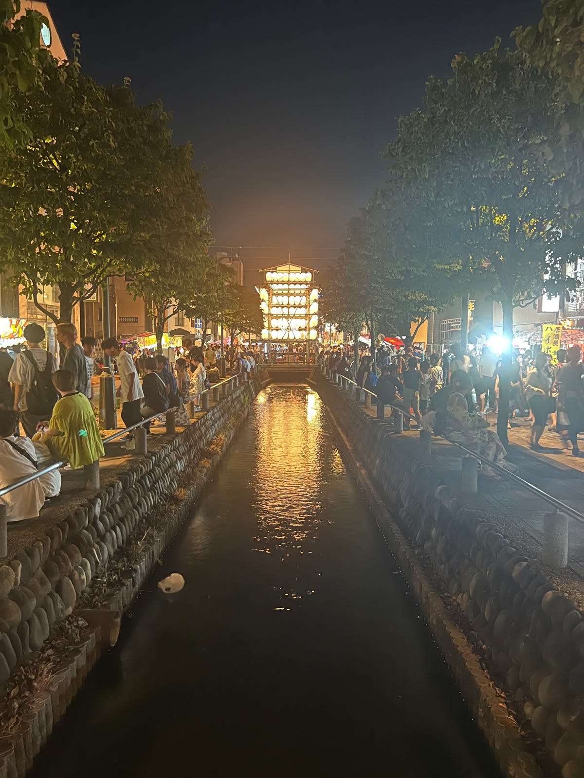 A canal lit up during a summer matsuri, Kumagaya